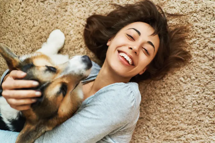 Woman snuggling with her dog after it was spayed