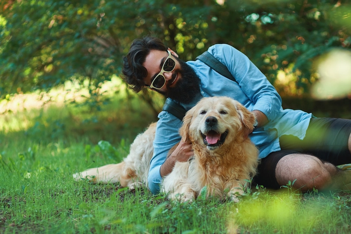 Man with beard and his small yellow dog playing