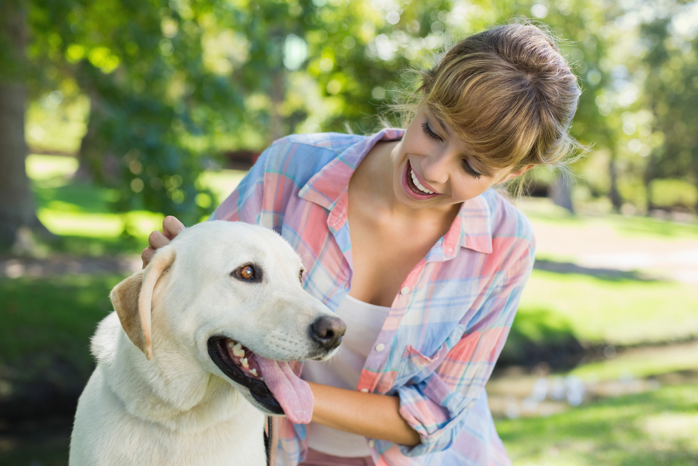 Blonde with her labrador in the park