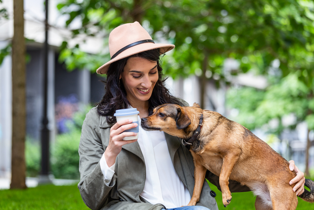 Happy hipster woman playing with her dog